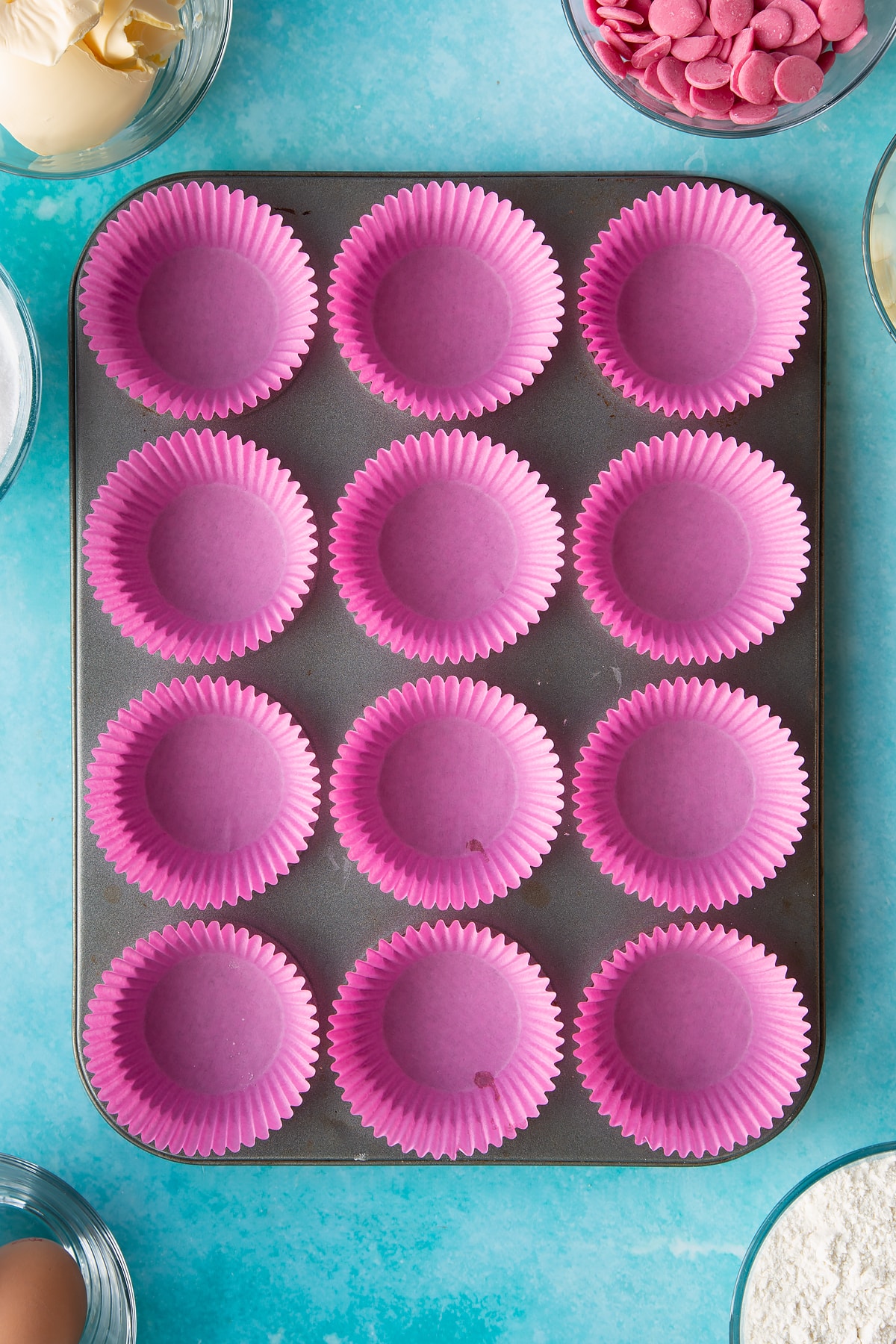 pink cupcake liners in a cupcake tray.