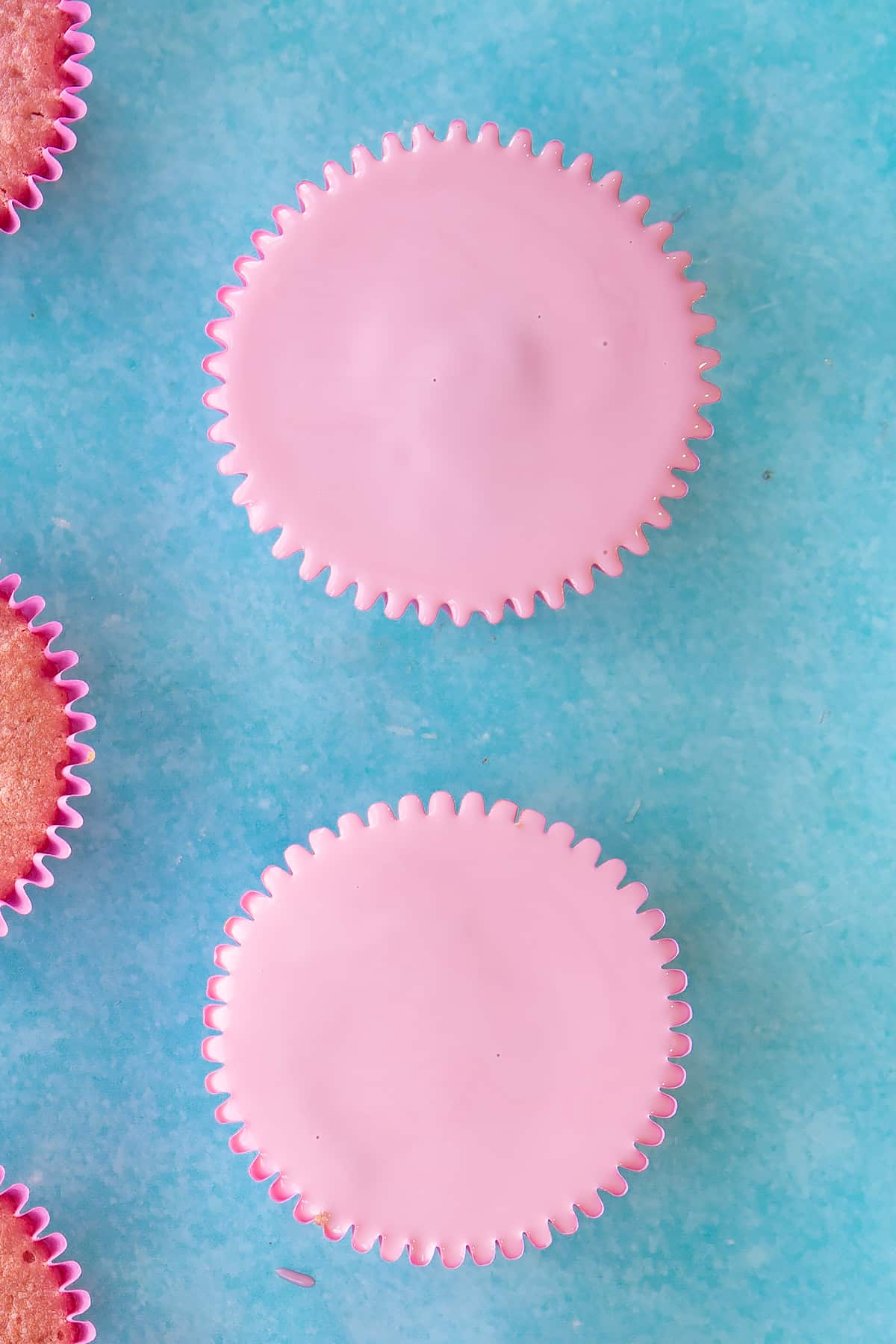 pink chocolate topping on a pink cupcake in a pink cupcake liner.