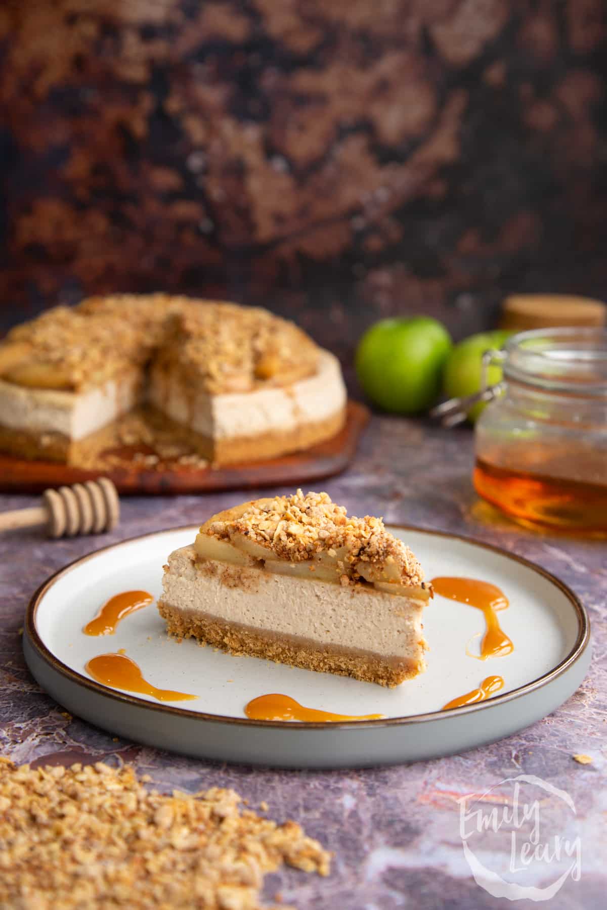 A finished slice of apple crumble cheesecake on a white plate.