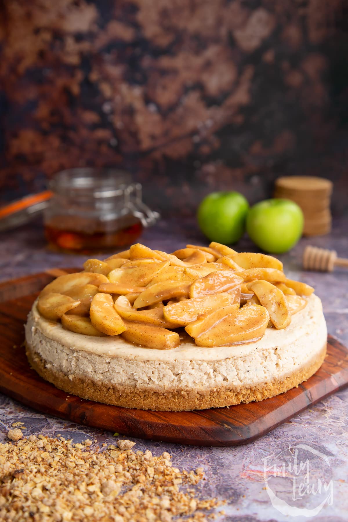 Adding the apples to the top of the cheesecake.