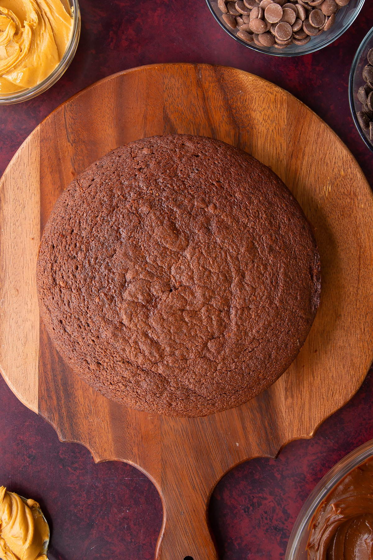 a cooked chocolate peanut butter cake on a wooden chopping board.