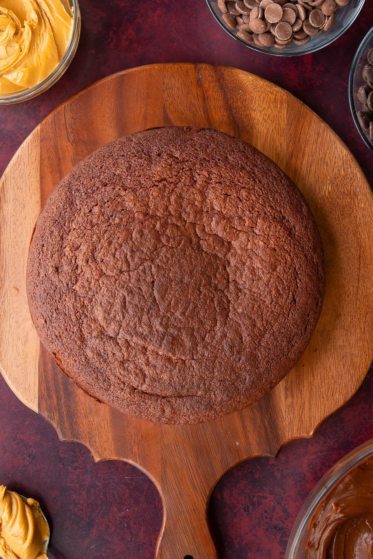 a cooked chocolate peanut butter cake on a wooden chopping board.