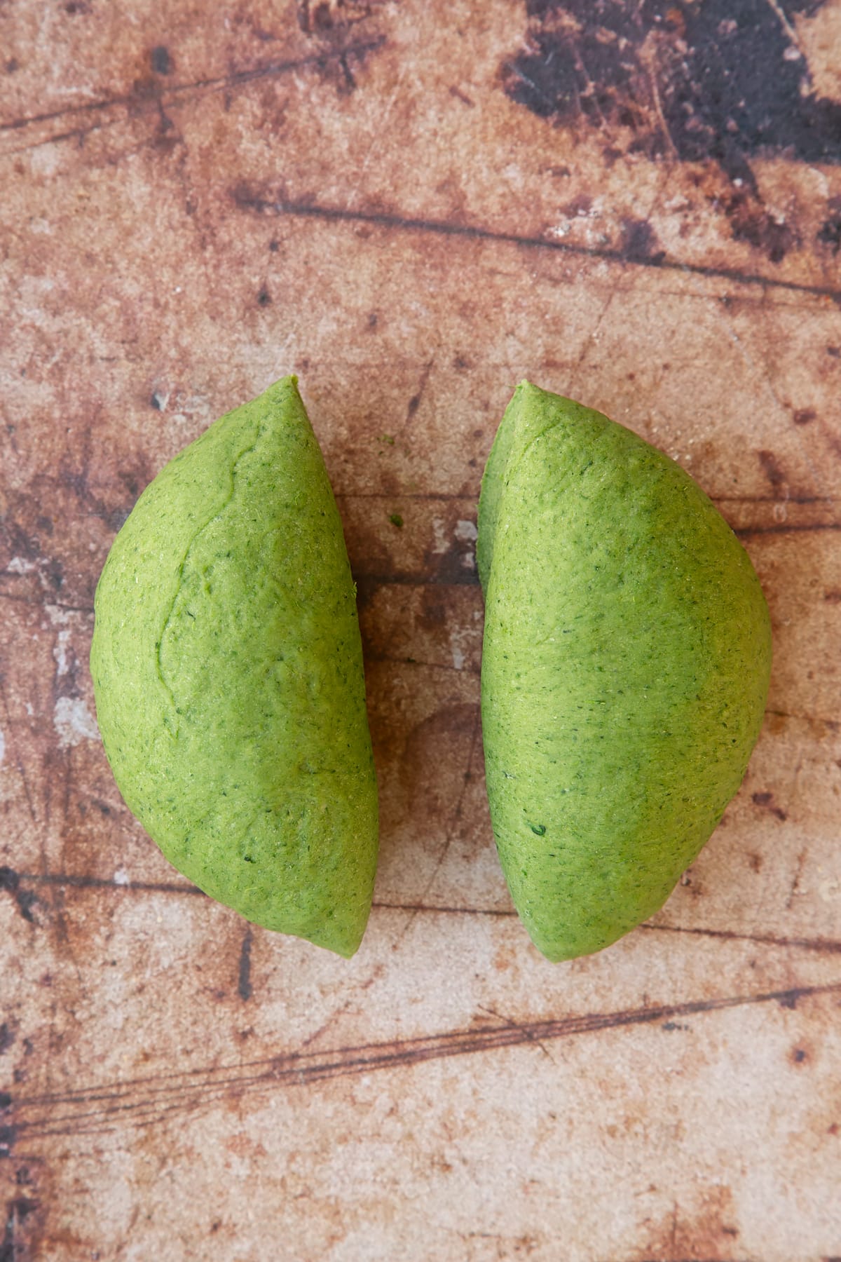 smooth tagliatelle verdi pasta dough divided into two portions.