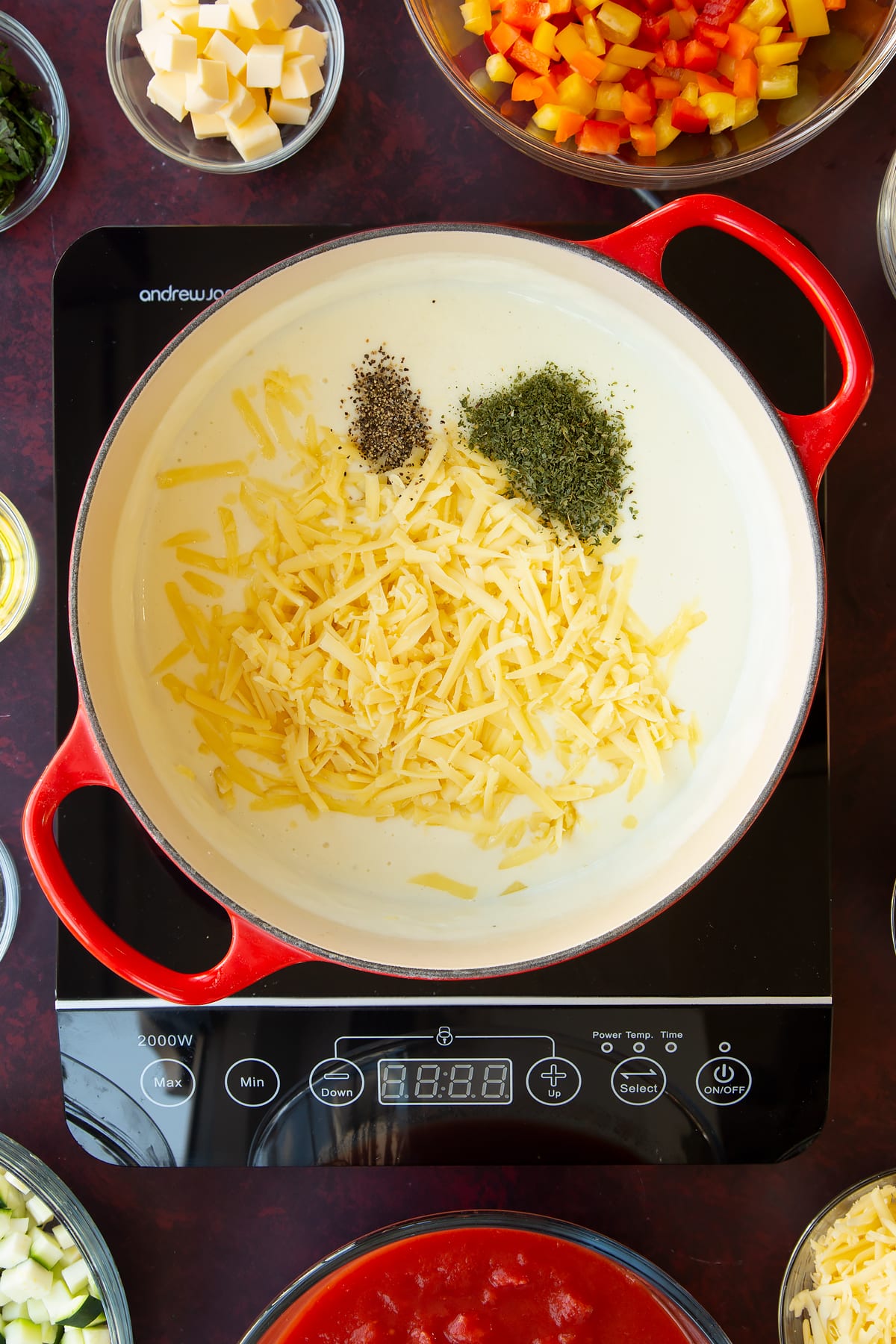 Overhead shot of the white sauce ingredients in a red pan.