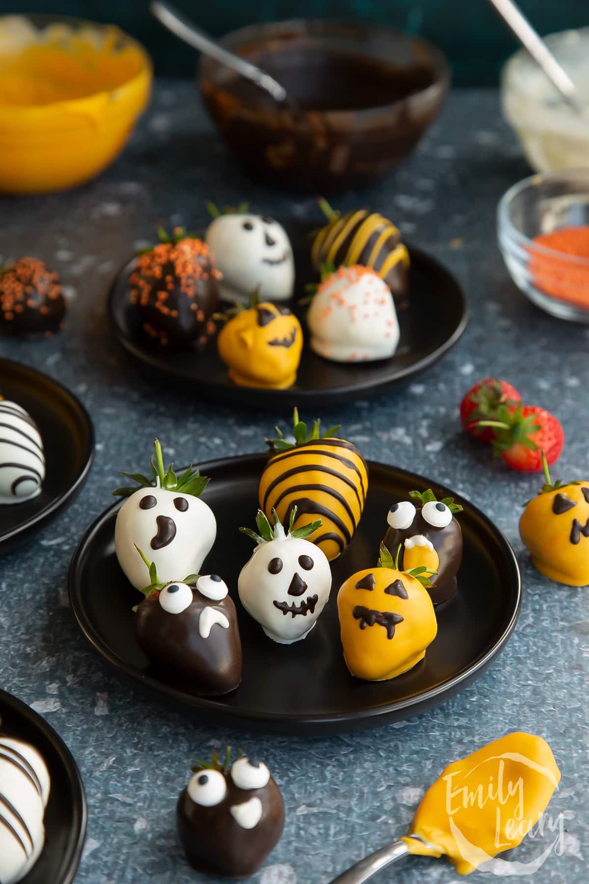 A plate of finished halloween chocolate covered strawberries.