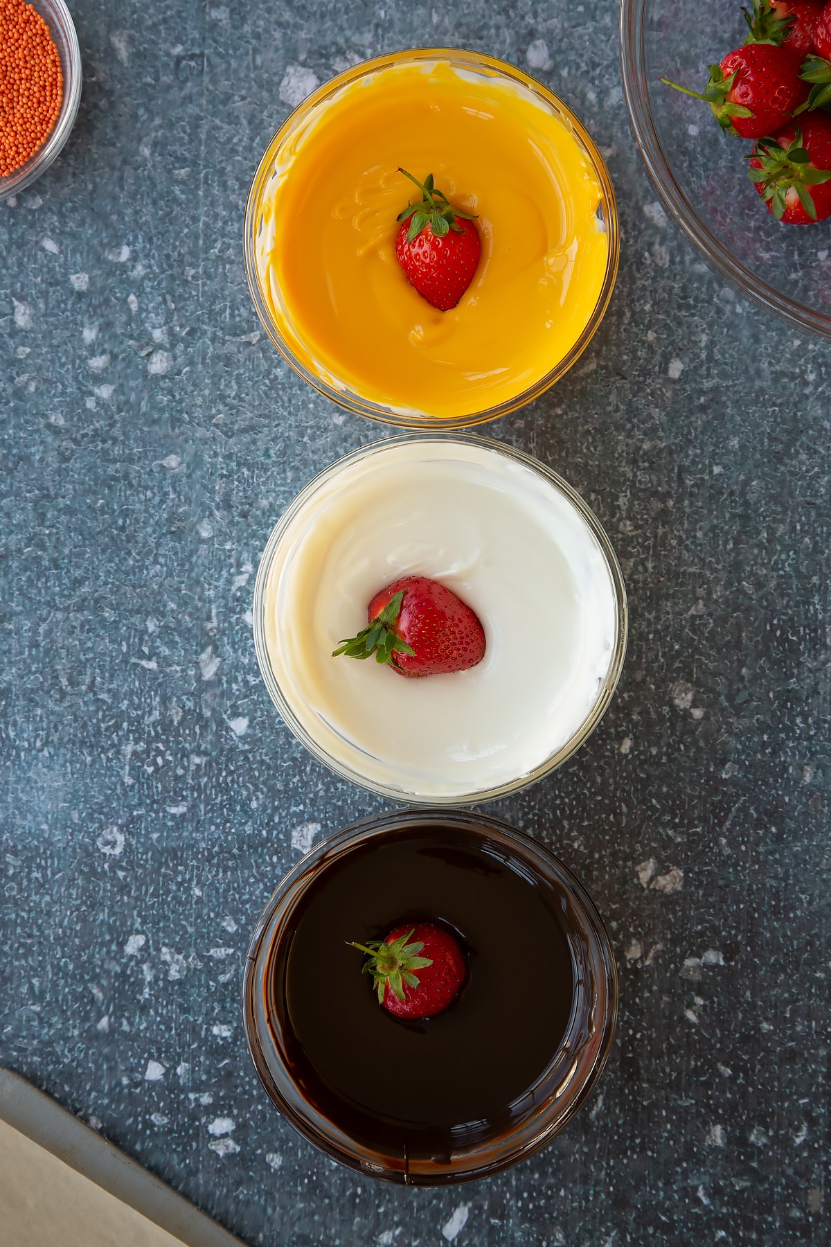 Dipping strawberries into the melted chocolate.