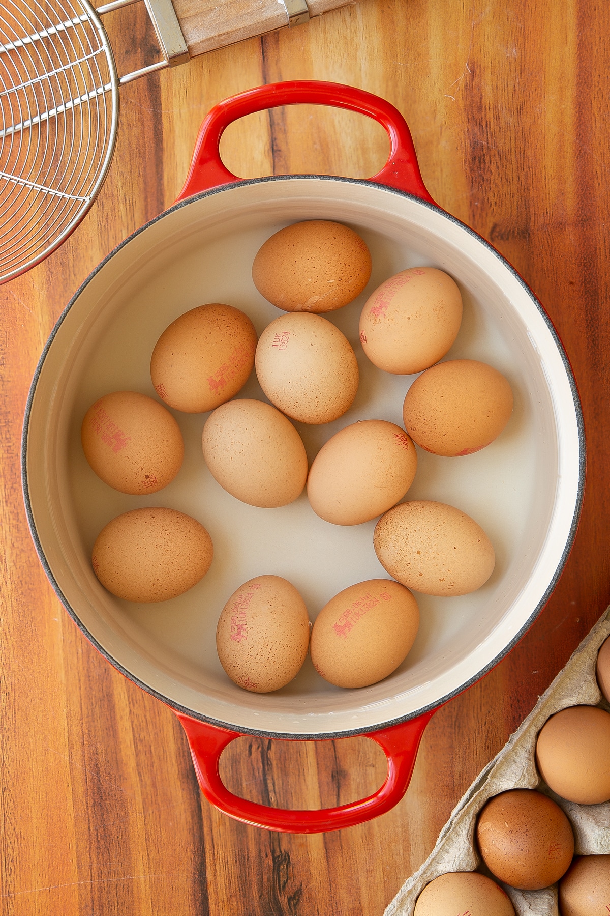 Eggs inside of a large red pan.