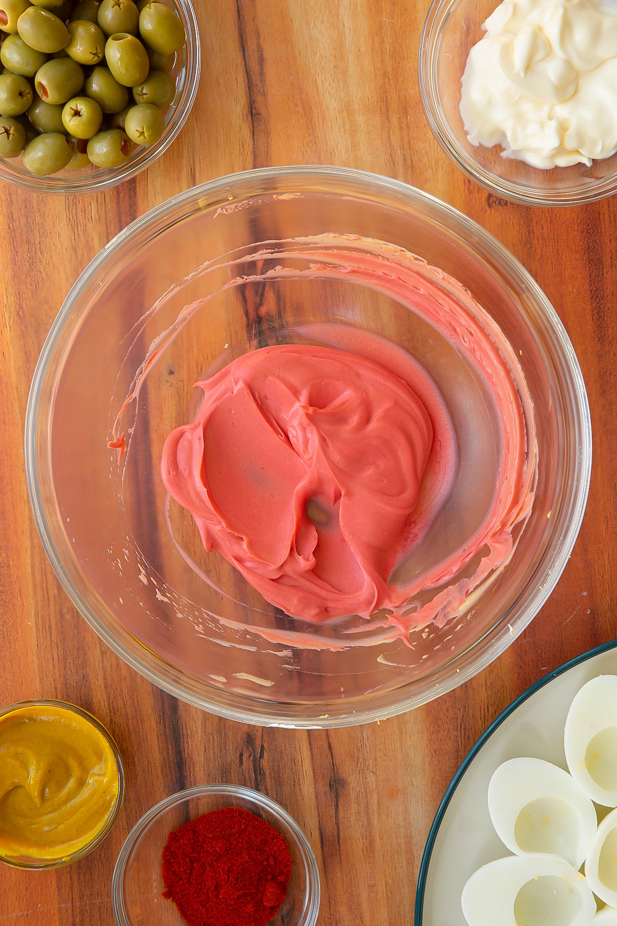 Adding red food colouring to a third of the mixture.