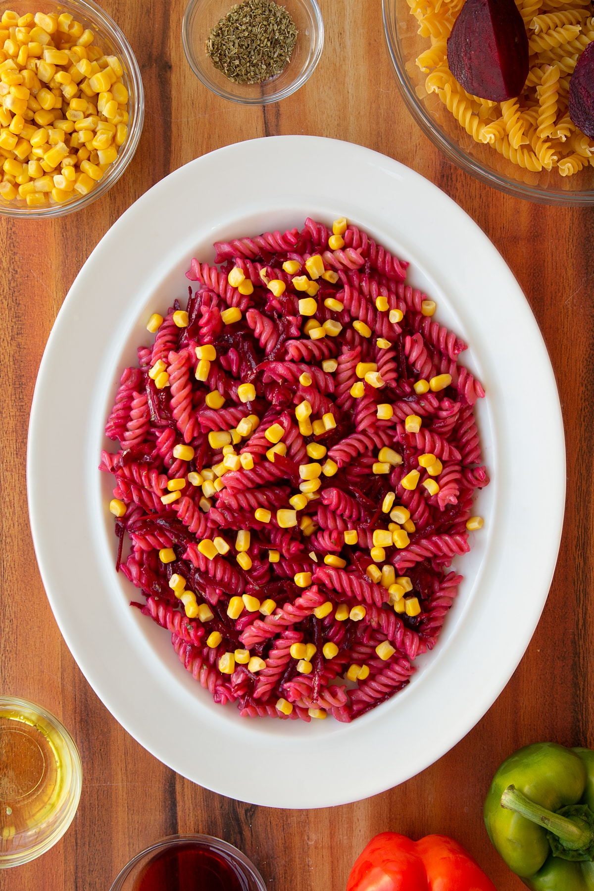Adding the sweetcorn ontop of the beatroot pasta salad.