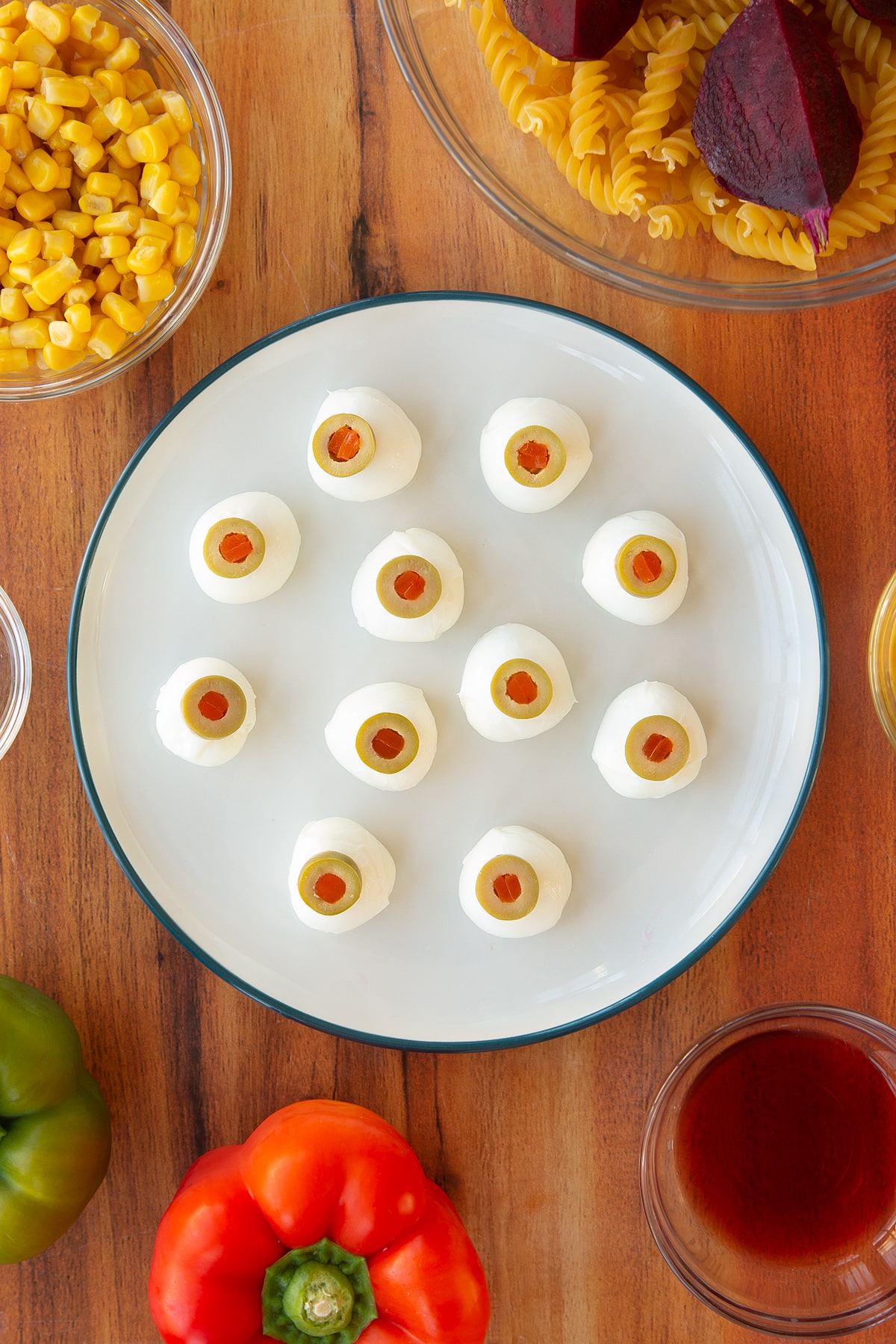 A plate of mozzarella eyeballs on a white plate.