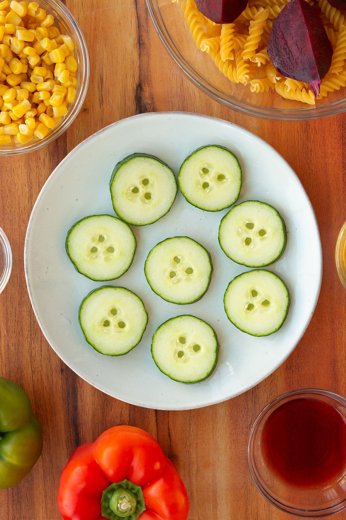 Overhead shot of the cucumber slices after a straw has been used to cut holes into the slices.