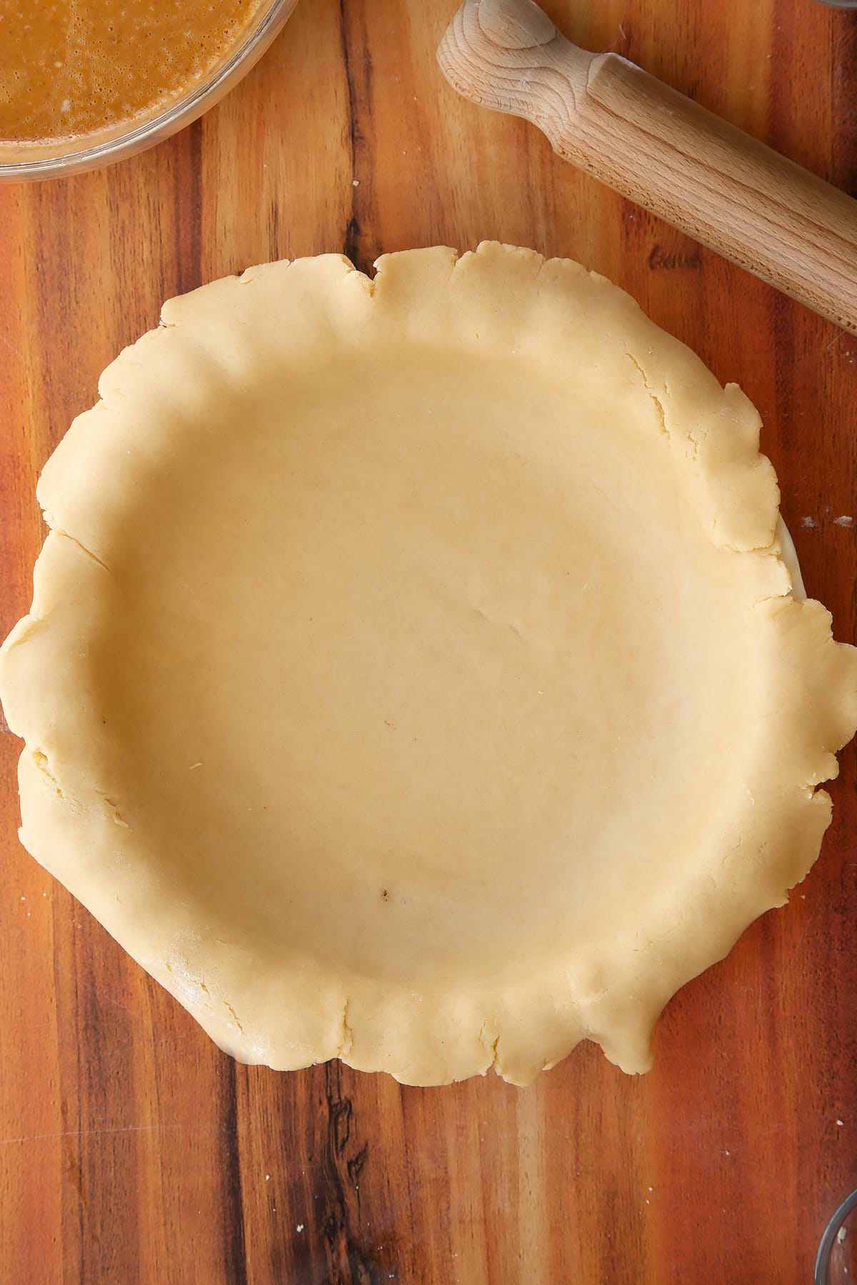 Lining the caramel pumpkin pie dough into the pie dish.