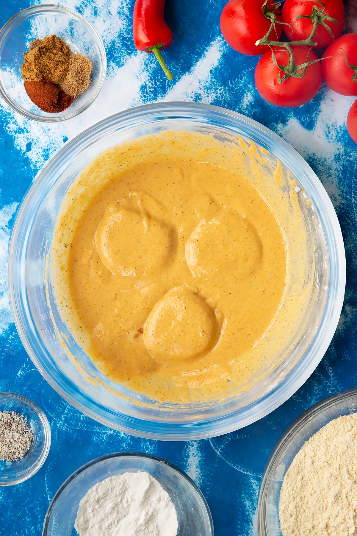 Covering both sides of the sliced tomatoes in the tomato pakora batter mixture.