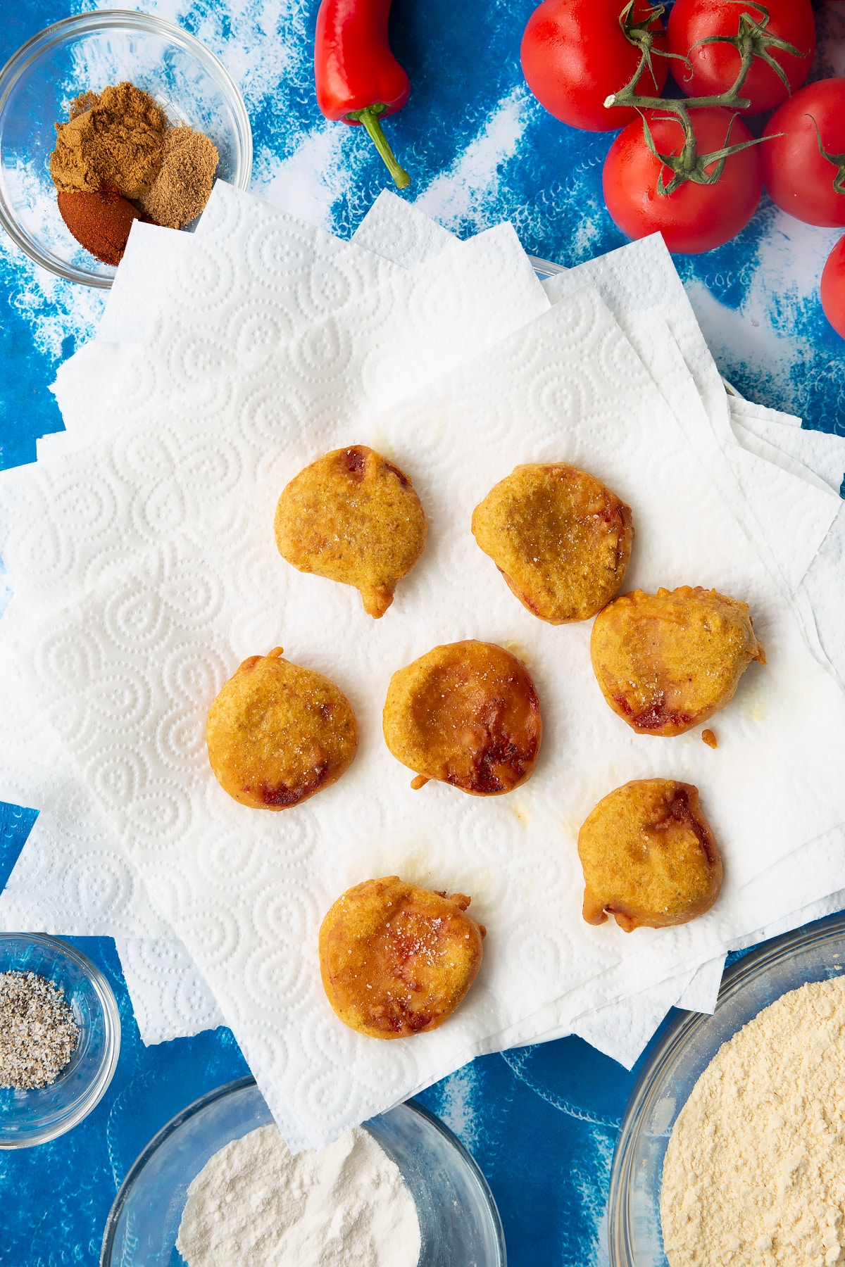 Overhead shot of the tomato pakora drying on some paper towels.